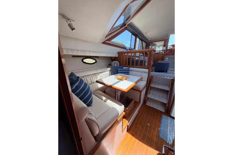 Slide: The Image of Interior of 1990 Californian 48 Motor Yacht with cozy seating and wooden accents. - 80