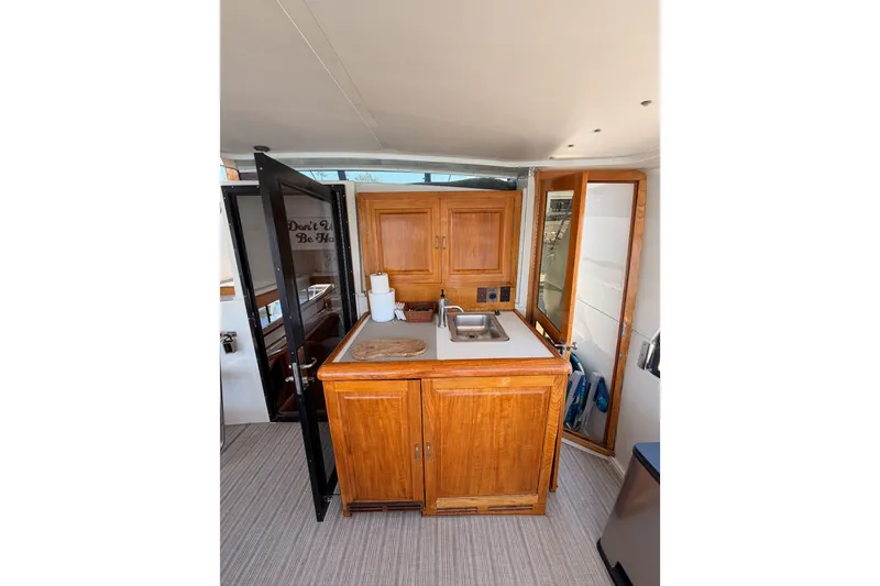 Slide: The Image of Interior of 1990 Californian 48 Motor Yacht with wooden cabinetry and compact sink area. - 16