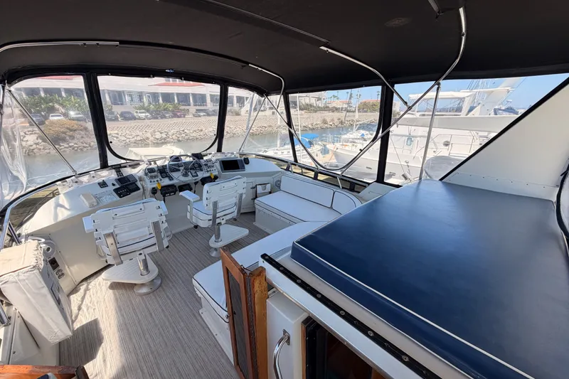Slide: The Image of 1990 Californian 48 Motor Yacht interior with helm, seating, and marina view. - 29
