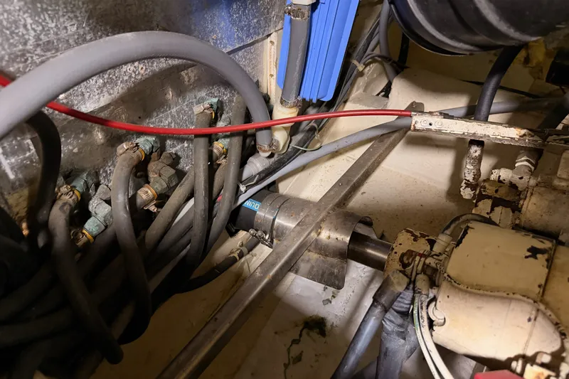 Slide: The Image of Engine room of a 1990 Californian 48 Motor Yacht with visible hoses and machinery. - 119