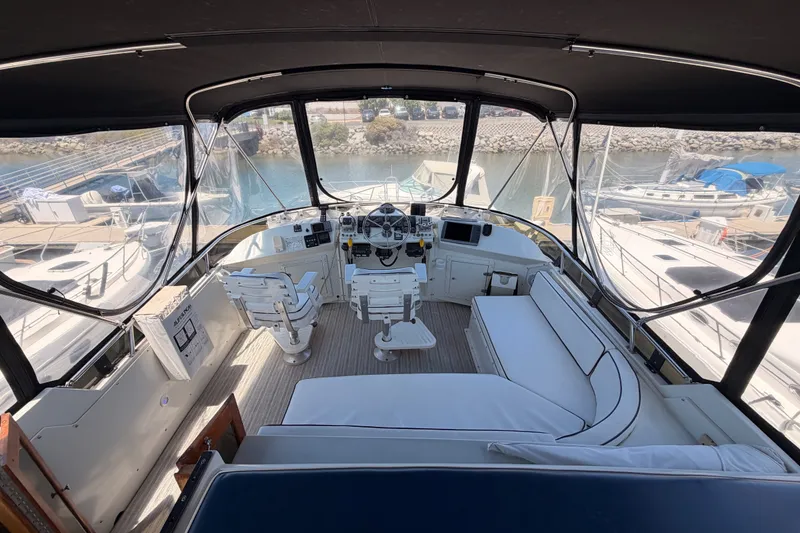 Slide: The Image of 1990 Californian 48 Motor Yacht cockpit with seating, helm, and marina view. - 34
