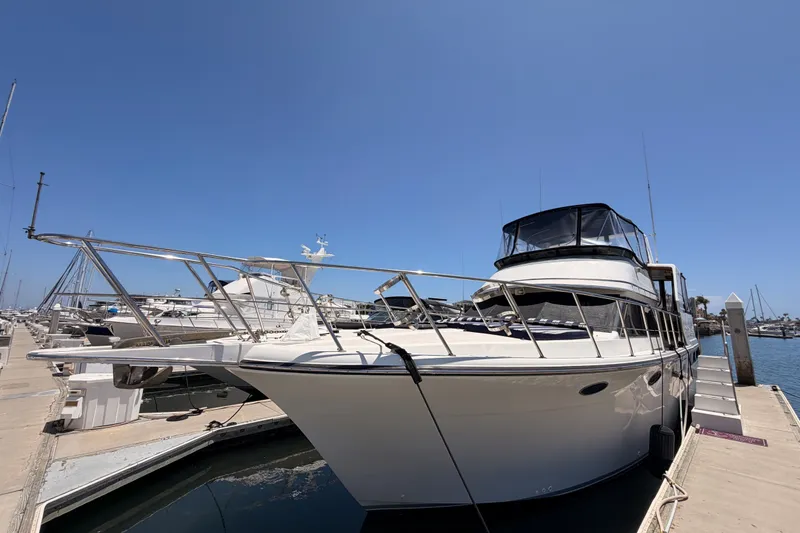 Slide: The Image of 1990 Californian 48 Motor Yacht docked at marina under clear blue sky. - 4