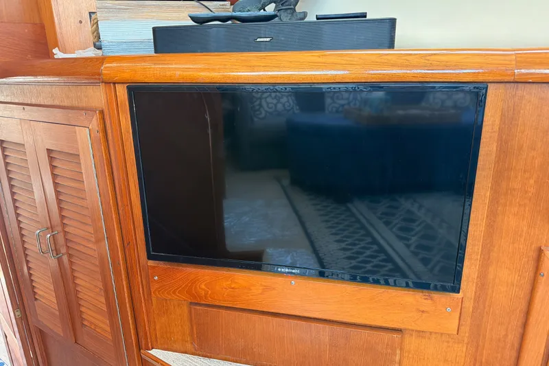 Slide: The Image of Flat-screen TV mounted on wooden panel inside 1990 Californian 48 Motor Yacht. - 91