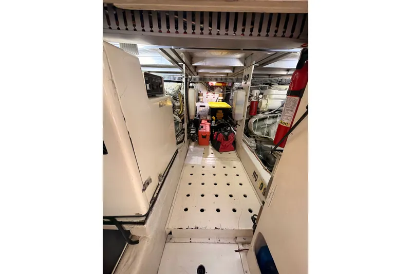 Slide: The Image of Engine room of a 1990 Californian 48 Motor Yacht with equipment and fire extinguishers. - 84
