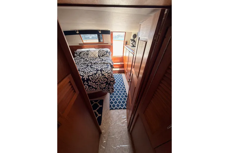 Slide: The Image of Cozy bedroom interior of 1990 Californian 48 Motor Yacht with patterned bedding and wooden accents. - 94
