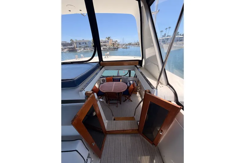 Slide: The Image of Californian 48 Motor Yacht 1990 interior with table, chairs, and marina view. - 51