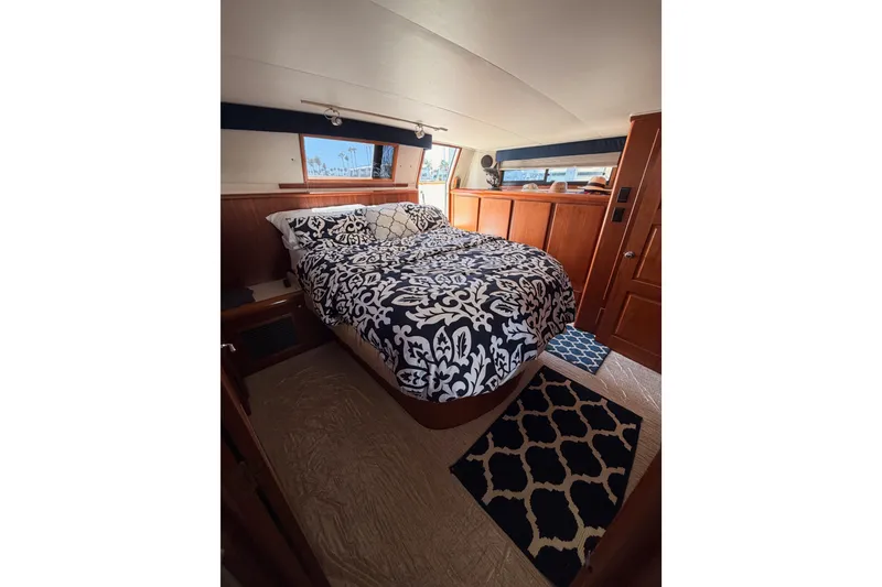 Slide: The Image of Luxurious bedroom interior of 1990 Californian 48 Motor Yacht with elegant bedding and wood finish. - 104