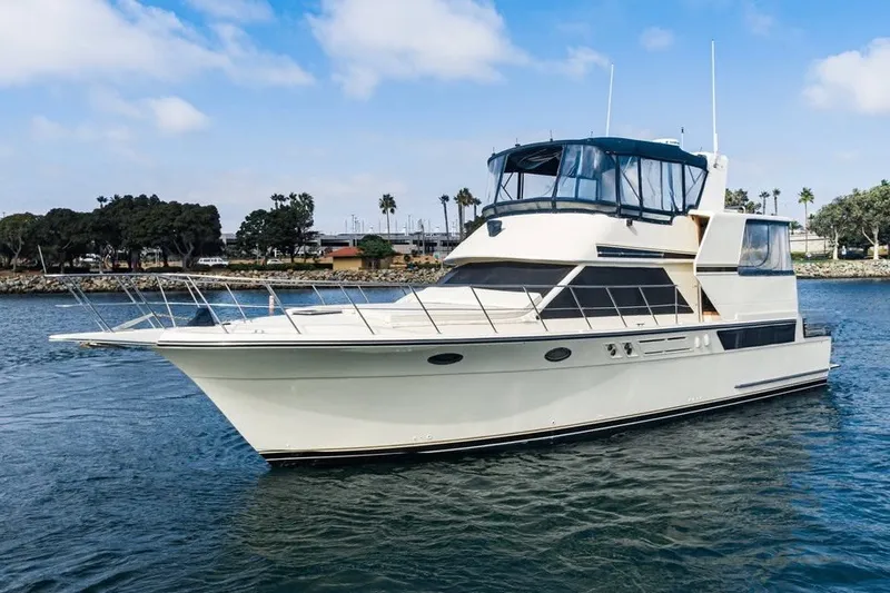The Image of 1990 Californian 48 Motor Yacht cruising on calm waters under a clear sky. - 0