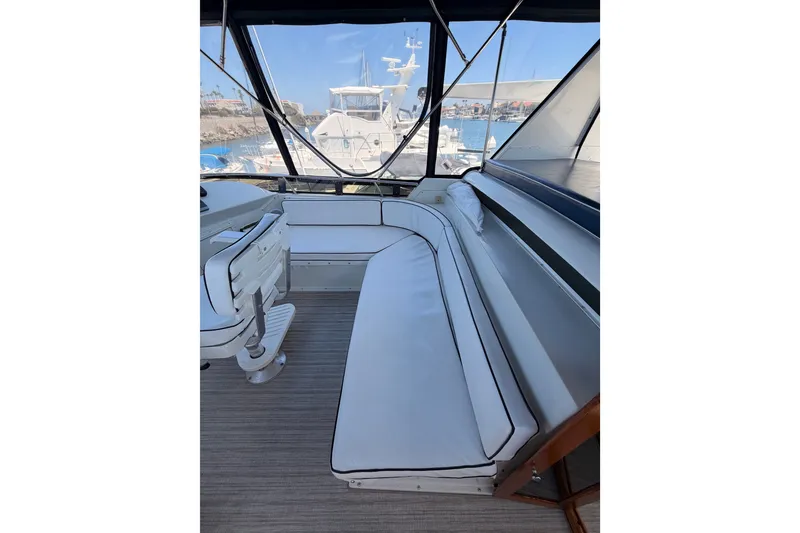 Slide: The Image of Interior view of 1990 Californian 48 Motor Yacht with white seating and helm. - 35