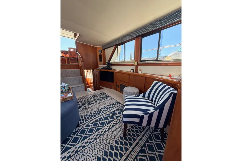 Slide: The Image of Interior of 1990 Californian 48 Motor Yacht with striped chair and nautical decor. - 87