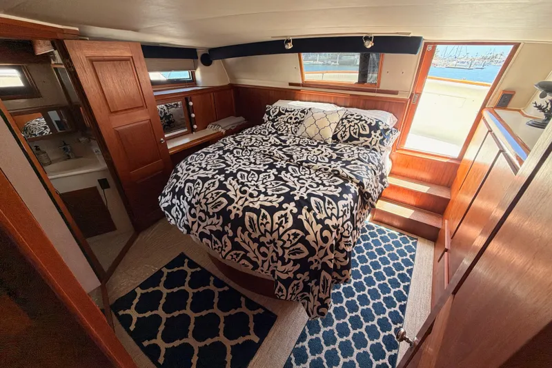 Slide: The Image of Cozy bedroom in 1990 Californian 48 Motor Yacht with nautical decor and patterned bedding. - 95
