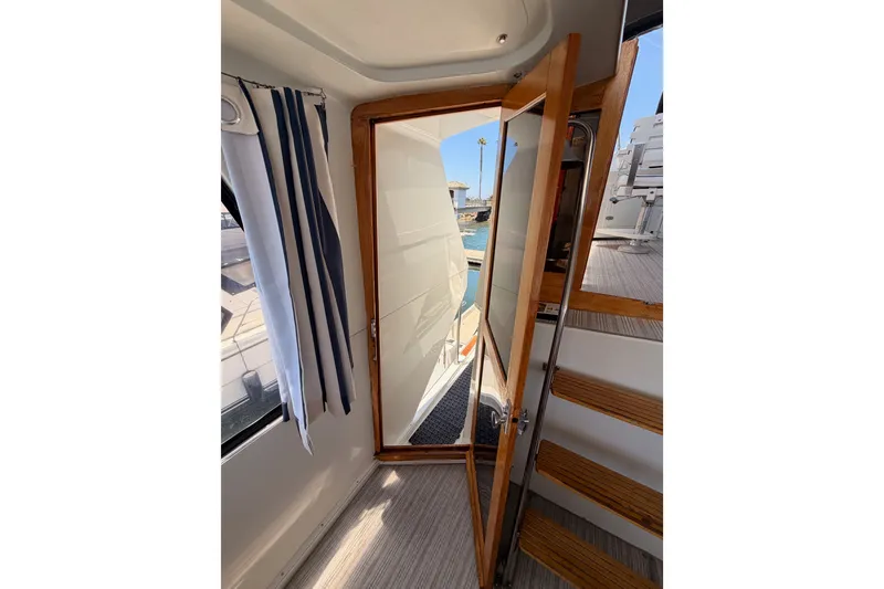 Slide: The Image of Interior view of 1990 Californian 48 Motor Yacht with wooden door and stairs. - 19