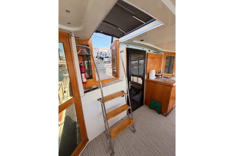 Slide: The Image of Interior of 1990 Californian 48 Motor Yacht with wooden cabinetry and ladder access. - 27