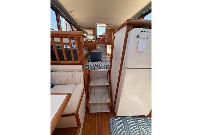 Slide: The Image of Interior of 1990 Californian 48 Motor Yacht with wooden accents and cozy seating area. - 82