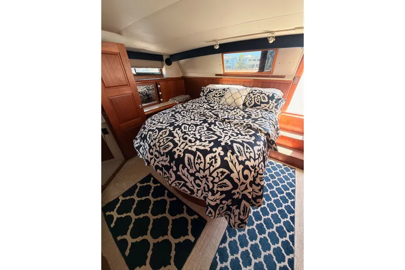 Slide: The Image of Luxurious bedroom interior of 1990 Californian 48 Motor Yacht with elegant bedding and wood accents. - 98