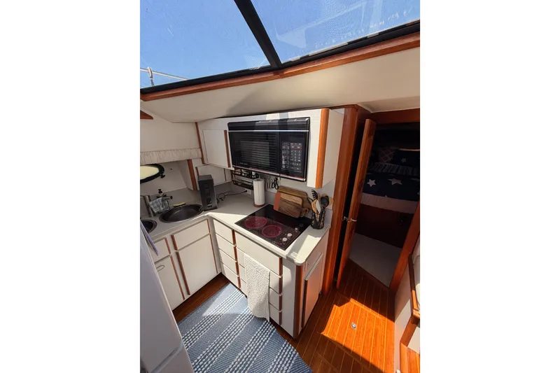 Slide: The Image of Interior of 1990 Californian 48 Motor Yacht kitchen with modern appliances and wood accents. - 63