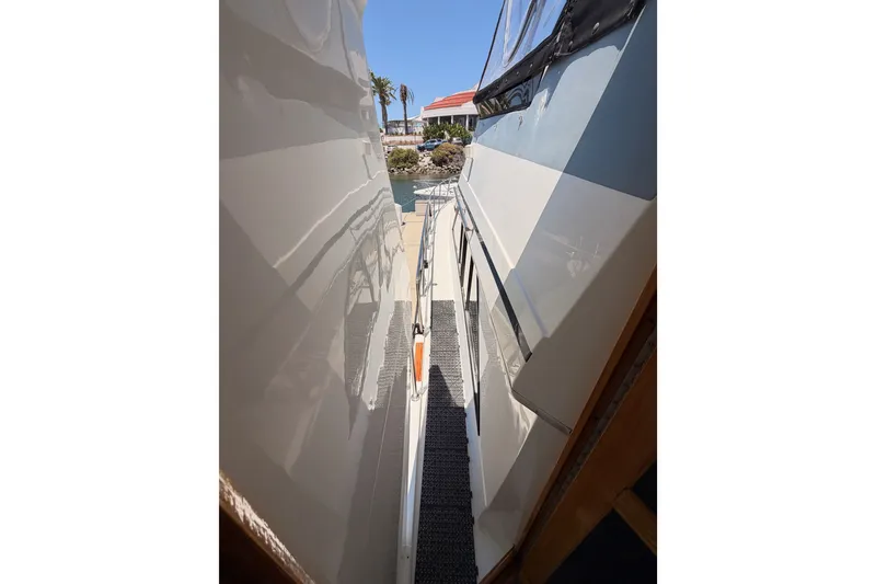 Slide: The Image of 1990 Californian 48 Motor Yacht side deck view with clear skies and palm trees. - 20
