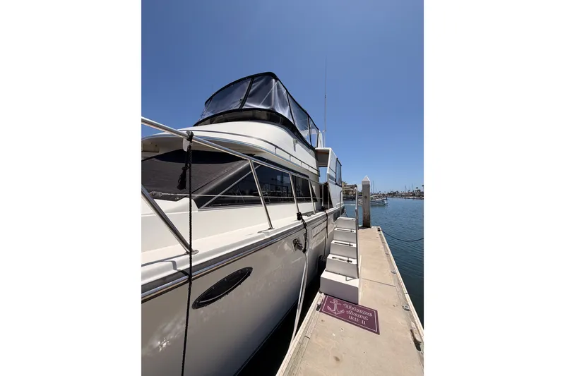 Slide: The Image of 1990 Californian 48 Motor Yacht docked at marina under clear blue sky. - 5
