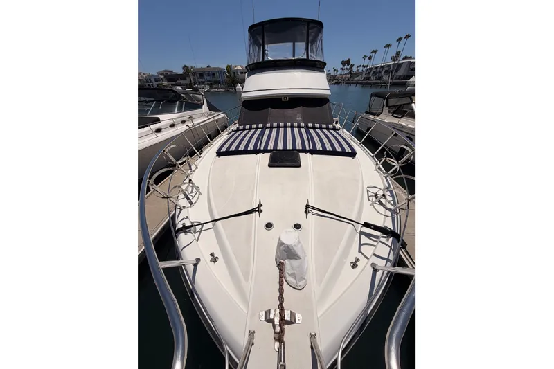 Slide: The Image of 1990 Californian 48 Motor Yacht docked, showcasing sleek design and spacious deck. - 24