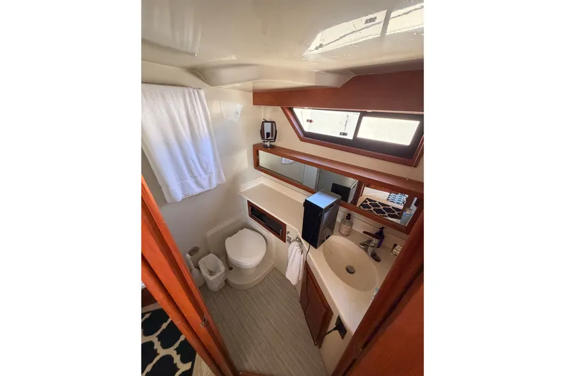 Slide: The Image of Bathroom interior of 1990 Californian 48 Motor Yacht with sink, toilet, and window. - 102