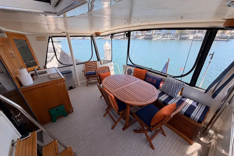 Slide: The Image of Spacious interior of 1990 Californian 48 Motor Yacht with elegant seating and scenic marina view. - 26