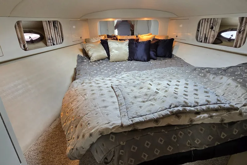 Slide: The Image of Cozy cabin interior of 2000 Wellcraft 45 Excalibur with plush bedding and pillows. - 29
