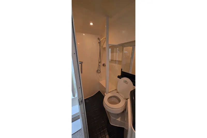 Slide: The Image of Bathroom interior of 2000 Wellcraft 45 Excalibur yacht, featuring shower and toilet. - 32