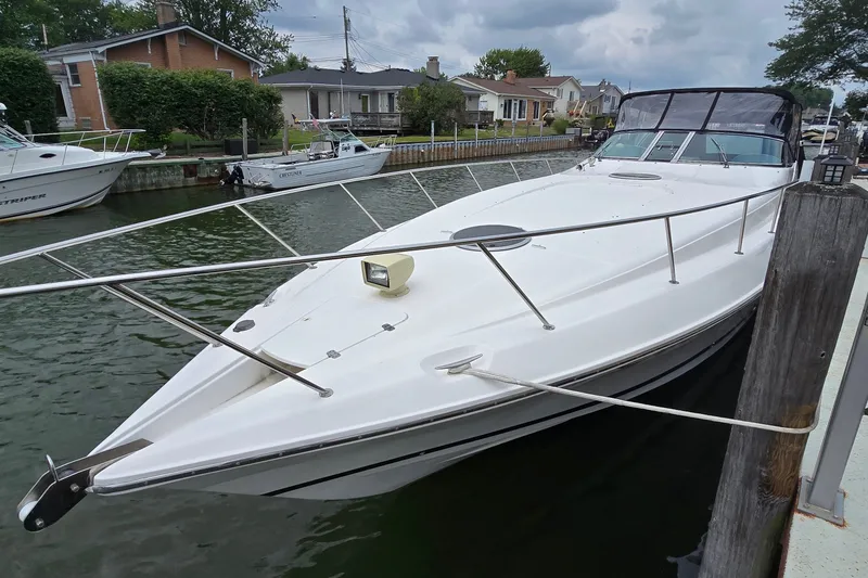 The Image of 2000 Wellcraft 45 Excalibur boat docked in a residential canal setting. - 1