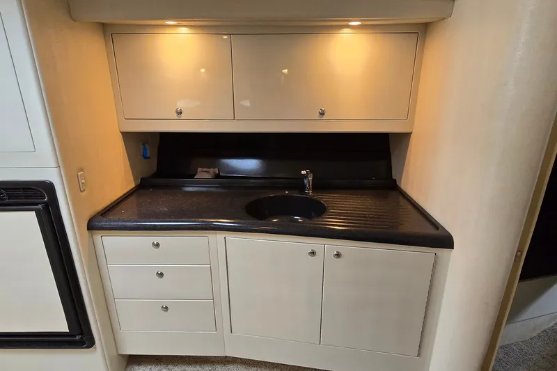 Slide: The Image of 2000 Wellcraft 45 Excalibur interior kitchenette with cabinets and sink. - 23