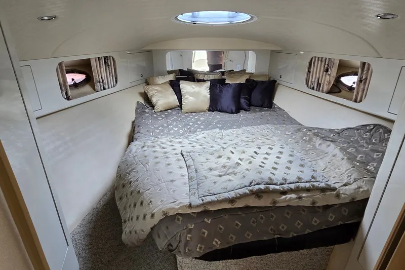 Slide: The Image of Luxurious cabin interior of 2000 Wellcraft 45 Excalibur with plush bedding and porthole windows. - 26