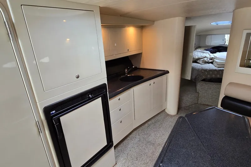 Slide: The Image of Interior of 2000 Wellcraft 45 Excalibur yacht, featuring kitchenette and cozy sleeping area. - 22
