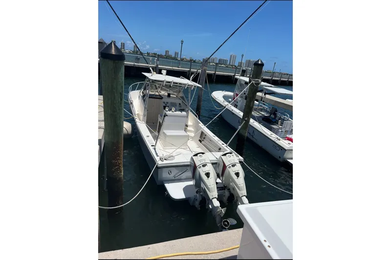 The Image of A 1992 Mako 253 Walk Around boat docked, featuring two outboard motors. - 0