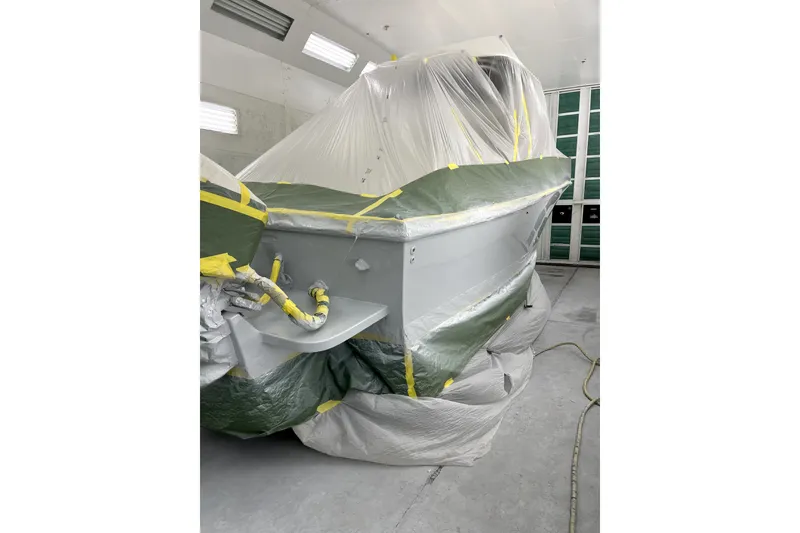Slide: The Image of 1992 Mako 260 Walk Around boat undergoing restoration, covered in protective plastic sheeting. - 13