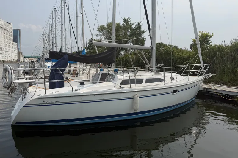 Slide: The Image of 2003 Catalina 28 MkII sailboat docked at a marina, surrounded by other boats. - 2