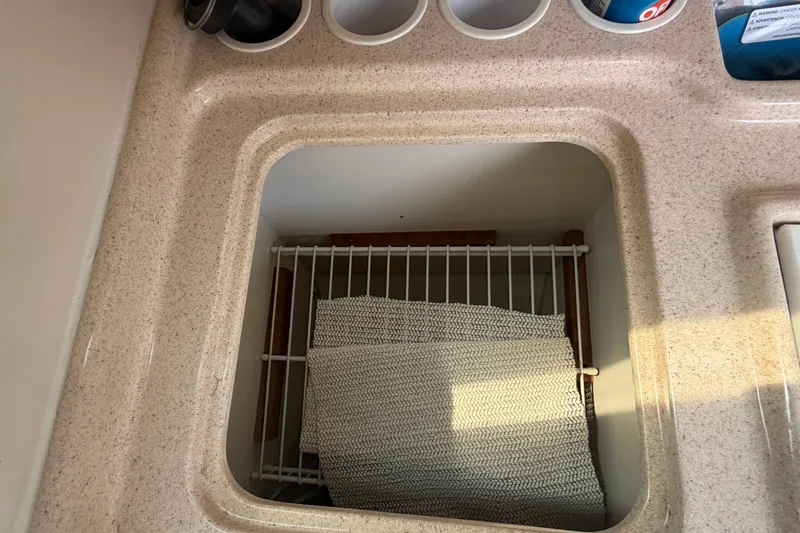 Slide: The Image of Catalina 28 MkII 2003 boat interior storage compartment with wire rack and textured mat. - 26