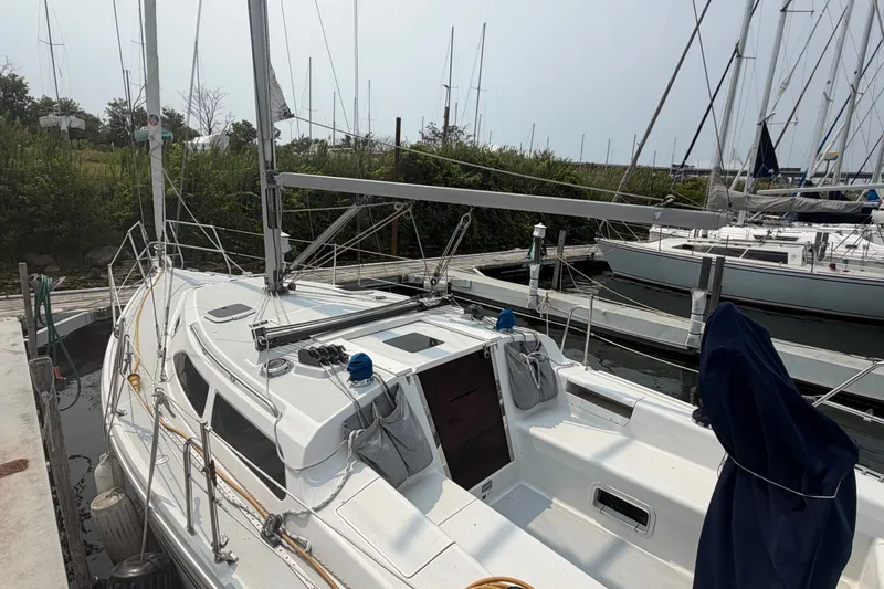 Slide: The Image of 2003 Catalina 28 MkII sailboat docked at a marina, surrounded by other boats. - 6