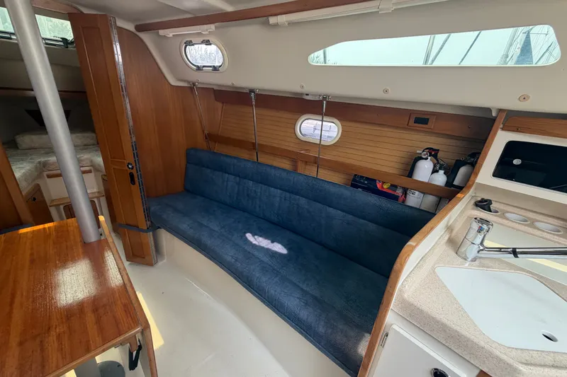 Slide: The Image of Interior of a 2003 Catalina 28 MkII sailboat with blue seating and wooden accents. - 15