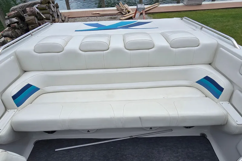 Slide: The Image of 1995 Powerquest 290 Enticer boat interior with white and blue seating by the water. - 11