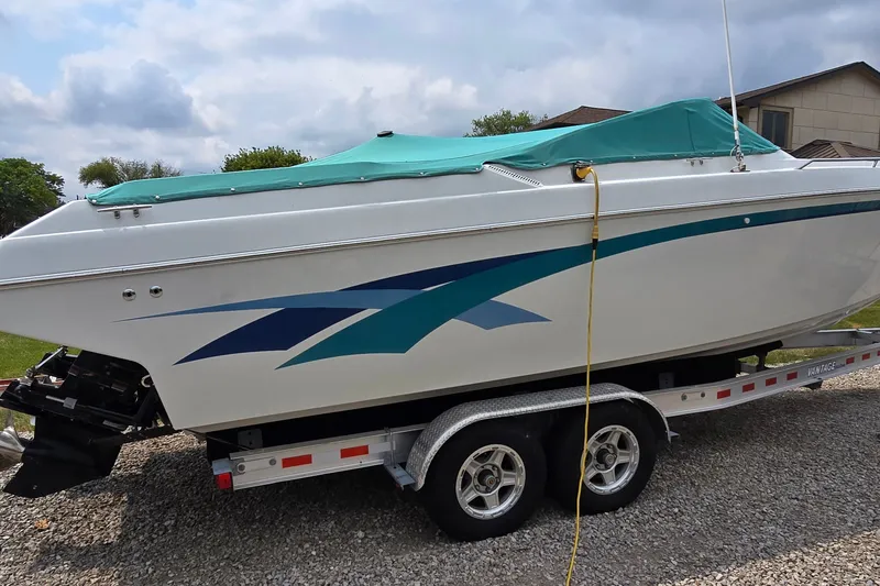 Slide: The Image of 1995 Powerquest 290 Enticer boat on trailer with teal cover and blue graphics. - 4