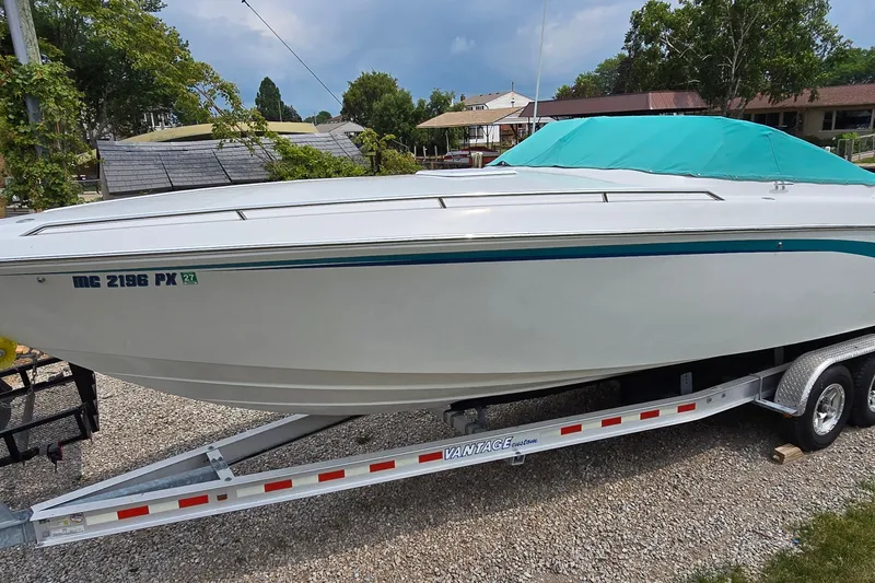 Slide: The Image of 1995 Powerquest 290 Enticer boat on trailer with teal cover, parked outdoors. - 5