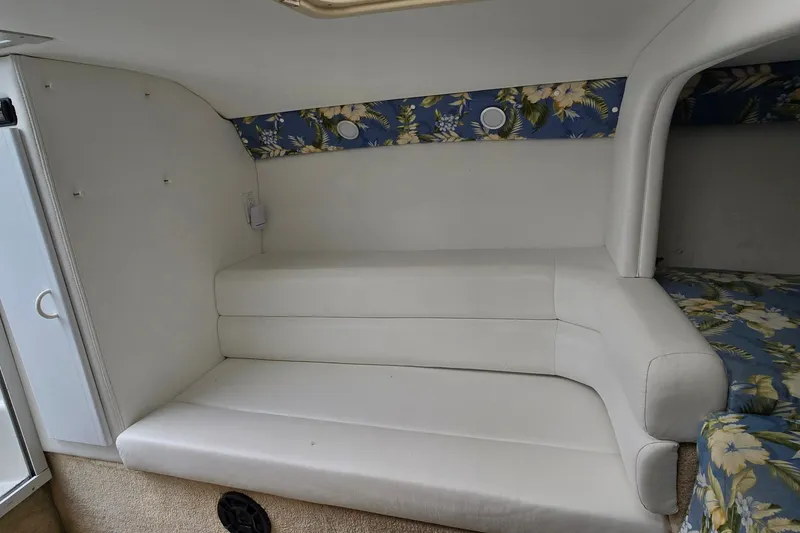 Slide: The Image of Interior cabin of 1995 Powerquest 290 Enticer with white seating and floral accents. - 19