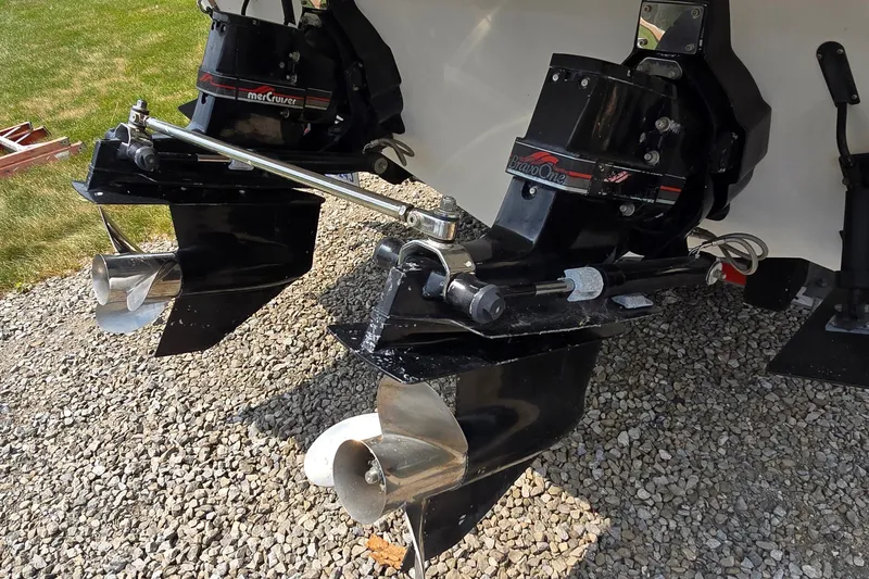 Slide: The Image of 1995 Powerquest 290 Enticer boat with dual MerCruiser Bravo One outdrives on gravel. - 3