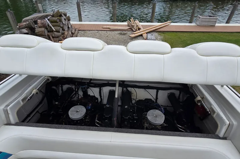 Slide: The Image of 1995 Powerquest 290 Enticer boat engine compartment with open white cushioned cover. - 27
