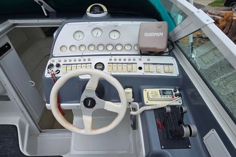 Slide: The Image of 1995 Powerquest 290 Enticer boat dashboard with steering wheel and Garmin navigation system. - 15
