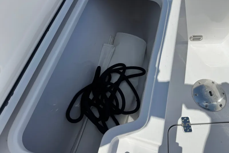 Slide: The Image of Storage compartment of 2024 Sportsman Heritage 231 Center Console with rope and cover. - 16