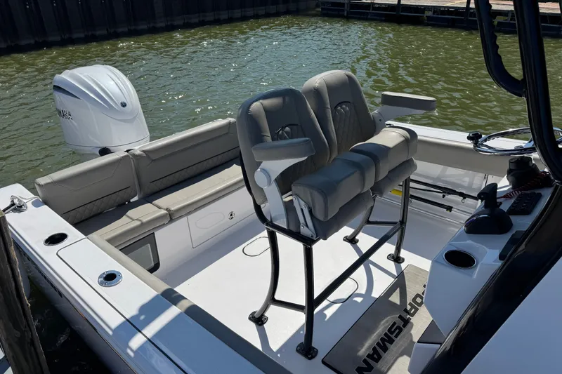 Slide: The Image of 2024 Sportsman Heritage 231 Center Console boat interior with seating and outboard motor. - 4