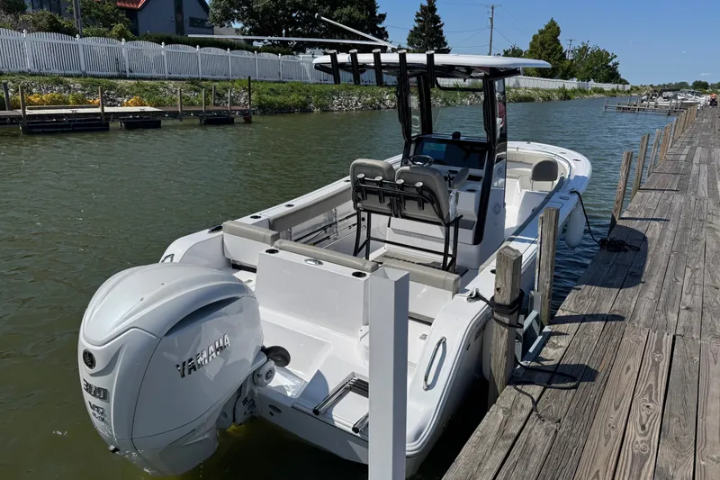 The Image of 2024 Sportsman Heritage 231 Center Console boat docked by wooden pier. - 0