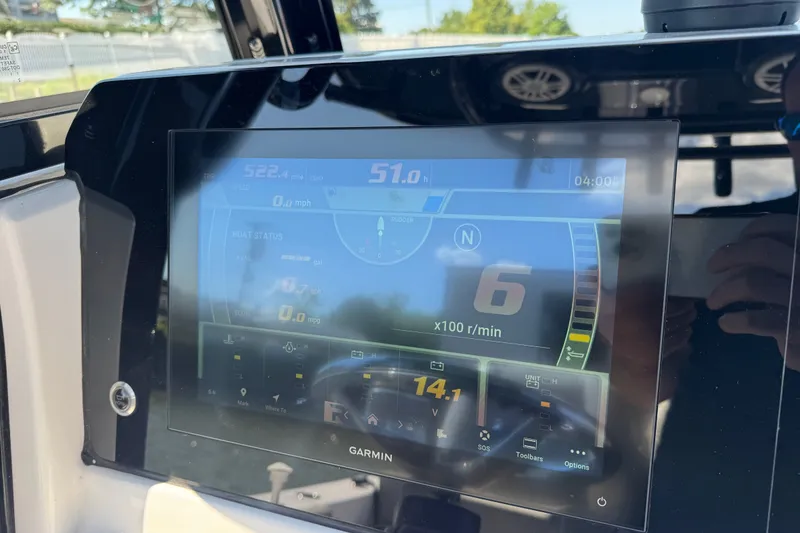 Slide: The Image of 2024 Sportsman Heritage 231 Center Console dashboard with Garmin display showing boat status. - 14