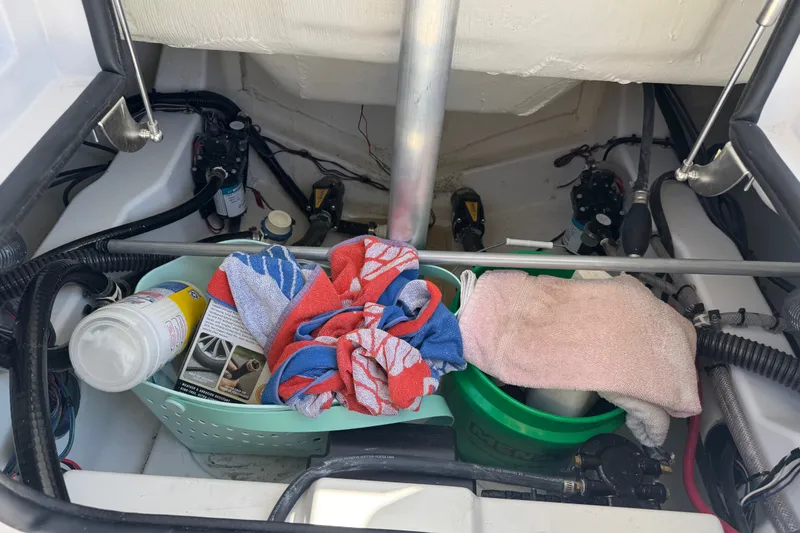 Slide: The Image of Storage compartment of 2024 Sportsman Heritage 231 Center Console with cleaning supplies and towels. - 28