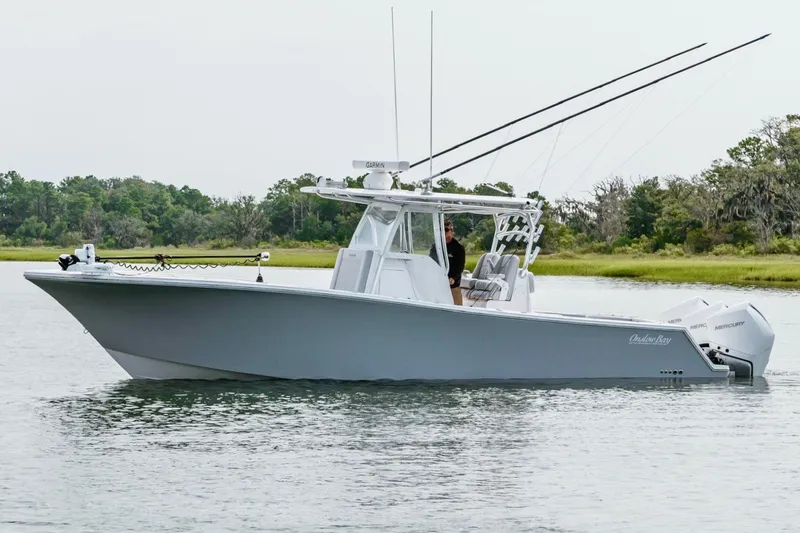 Slide: The Image of 2018 Onslow Bay 33 Tournament Edition boat on calm water with lush green background. - 4